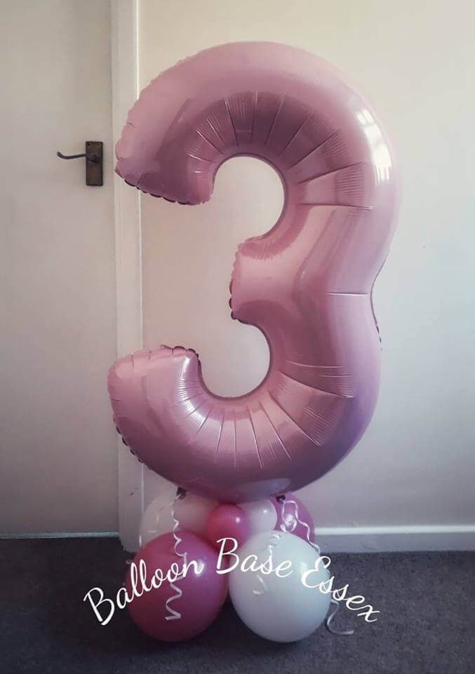 Pastel pink large number three on a base of pink and white balloons